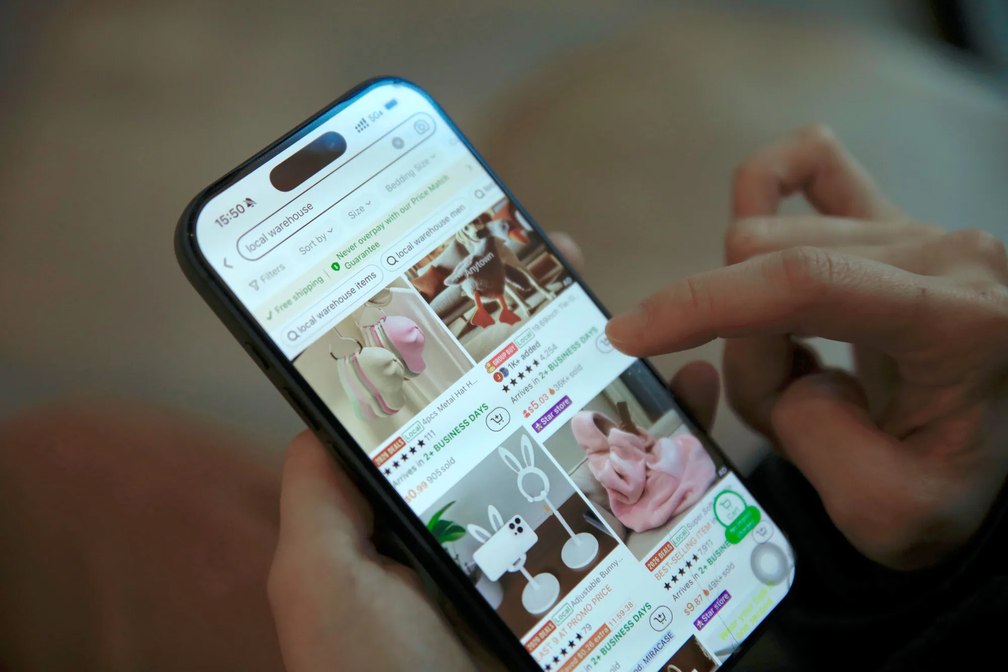 A shopper taps a smartphone screen showing an online store's product grid.