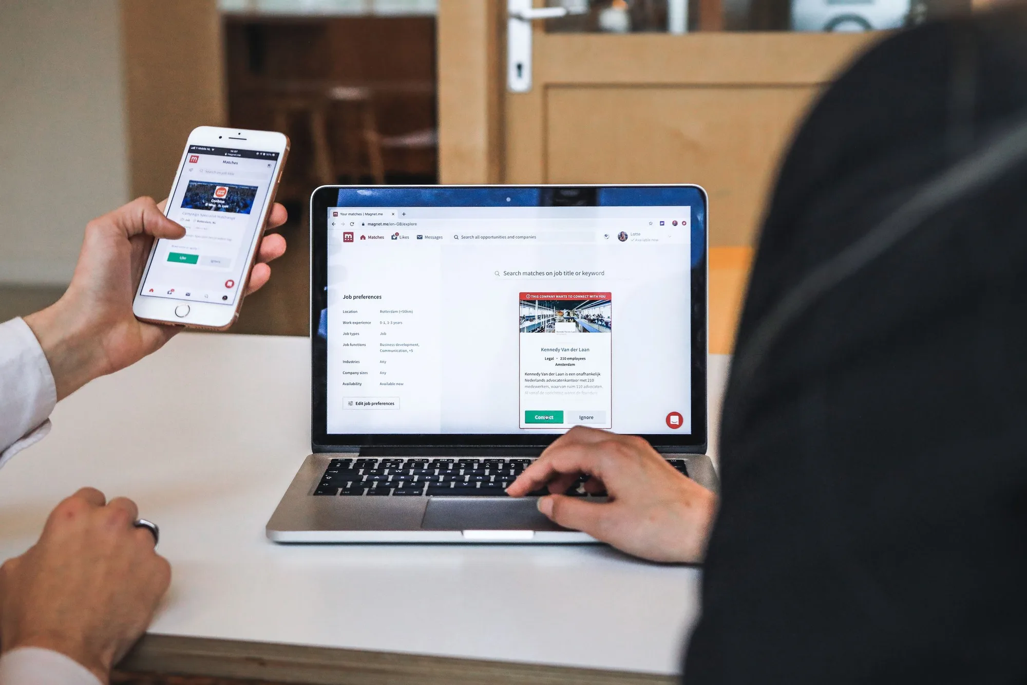 People browsing company and opportunity profiles on a laptop and smartphone.