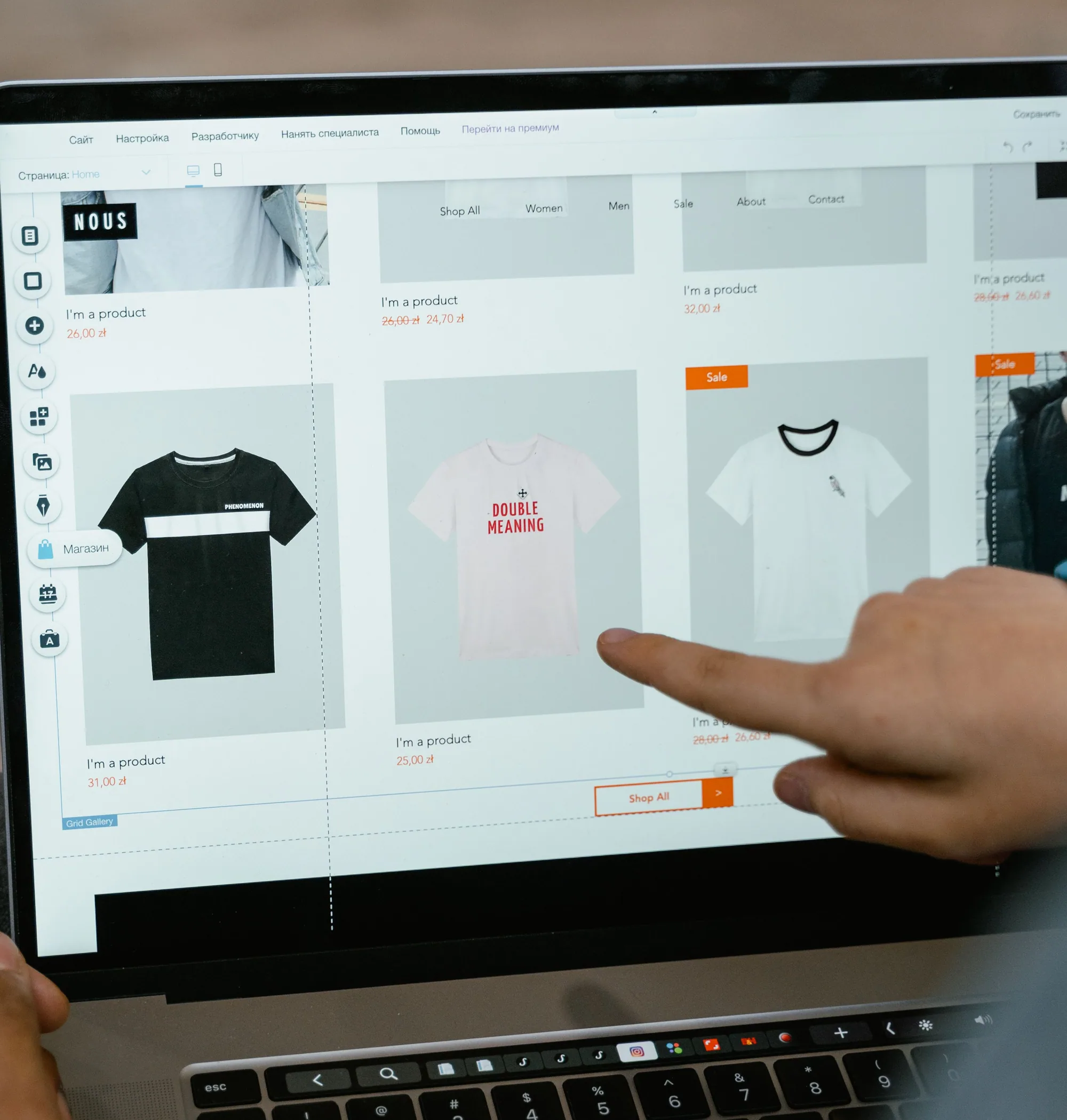 A person points at an online clothing-store layout on a laptop screen.